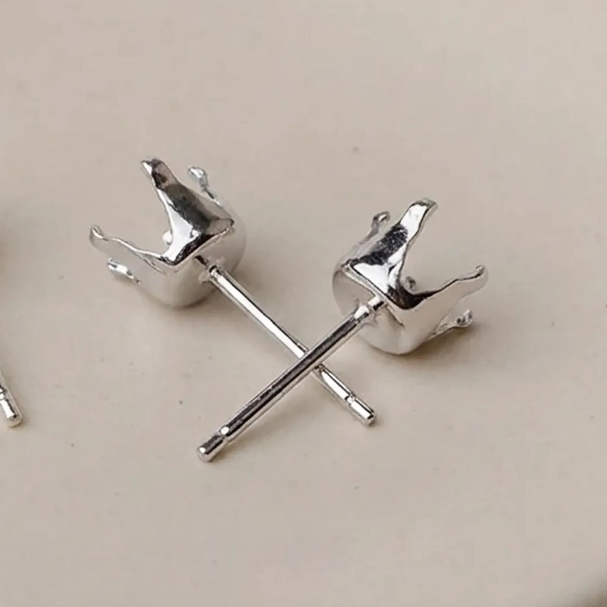 Close-up of 925 sterling silver 4-prong stud earring settings for round stones and crystals