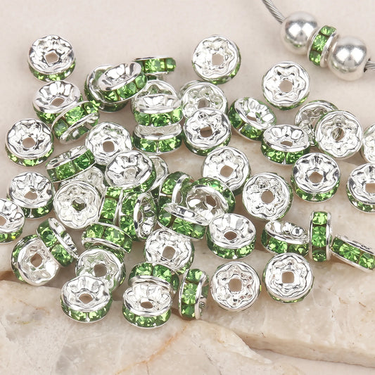 Green rhinestone rondelle spacer beads with silver color beads shown on jewelry wire