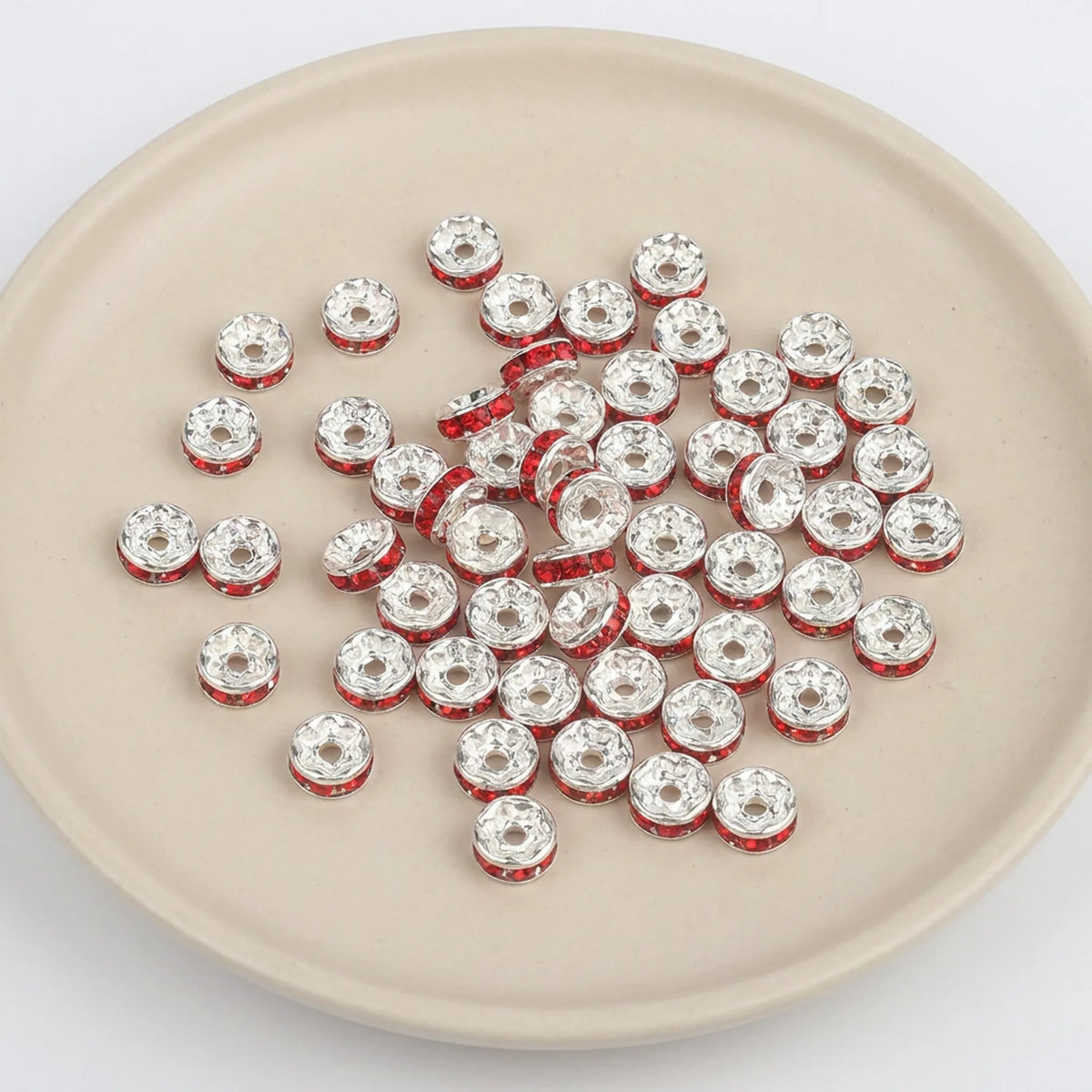 Light Siam crystal rhinestone spacer beads on display for jewelry making and beadwork