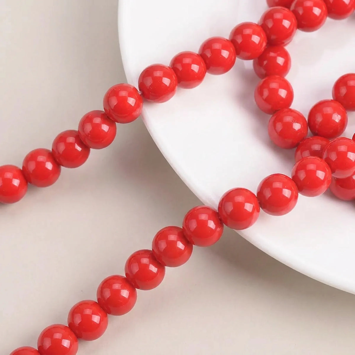 Macro view of smooth red coated glass round beads with glossy finish