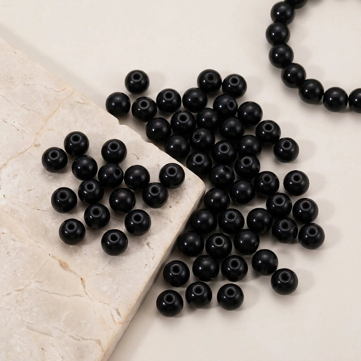 Close-up of black round glass pearl beads for jewelry making with pearl coated finish