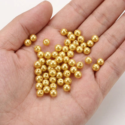 Champagne glass pearl beads shown in hand for size reference