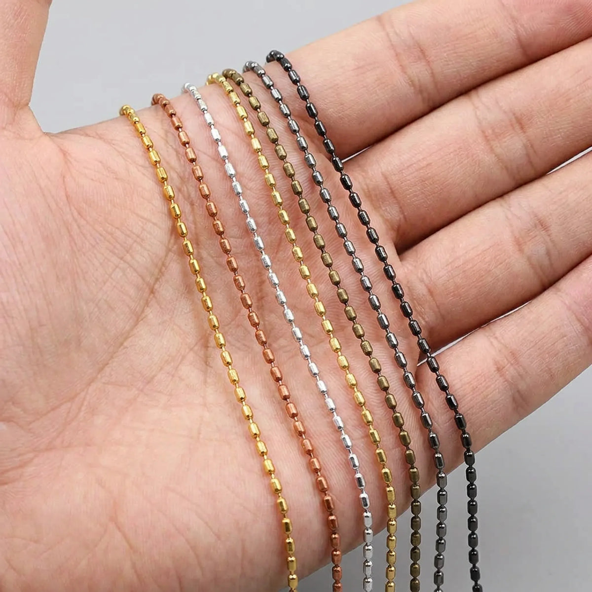 Cylindrical bead chain shown in hand for size comparison
