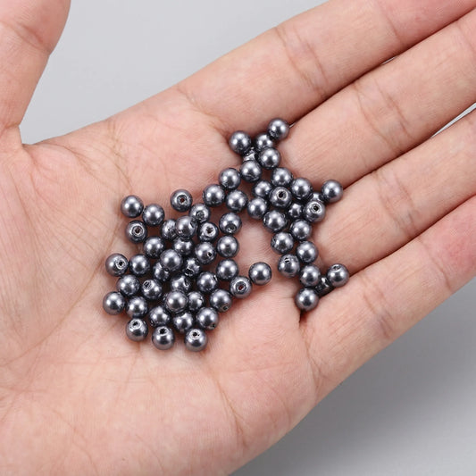 Dark Gray Glass Pearl Beads shown in hand for size comparison, pearl coated round glass beads for jewelry making