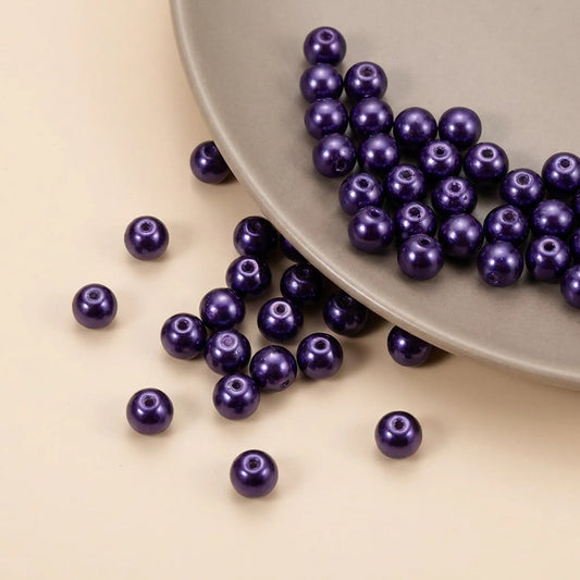Close-up of dark purple glass pearl beads with smooth pearl finish