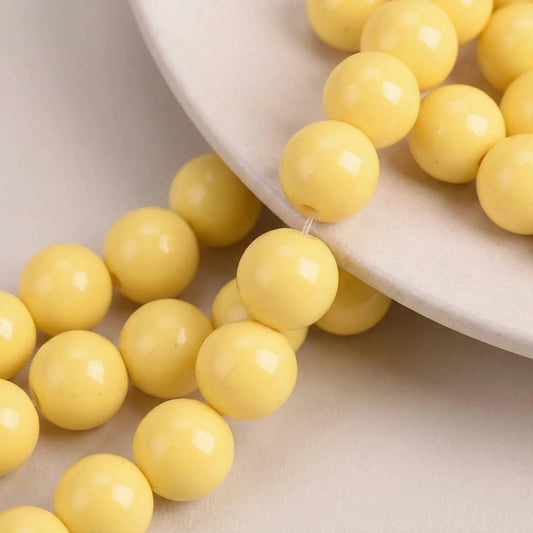 Close up of yellow coated opaque glass round beads