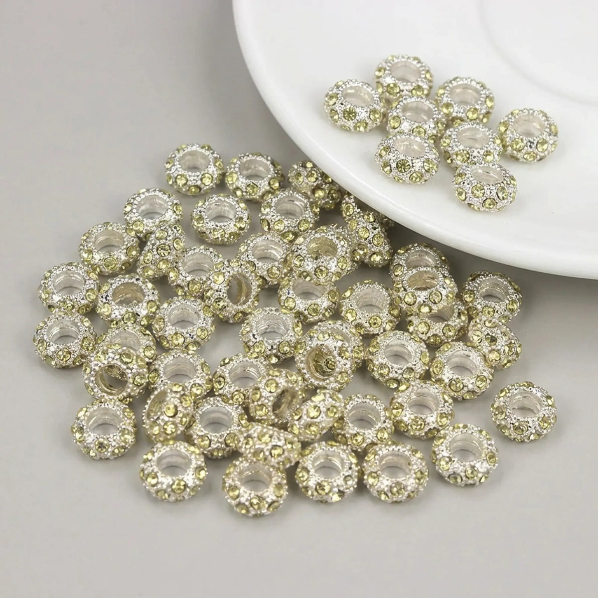 Light yellow rhinestone spacer beads with large holes and silver tone finish