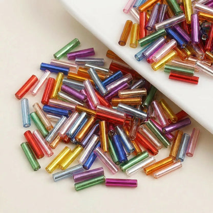 Close-up of mixed color 2x6mm long tube lined cylinder glass seed beads for jewelry making