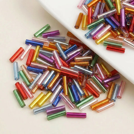 Close-up of mixed color 2x6mm long tube lined cylinder glass seed beads for jewelry making