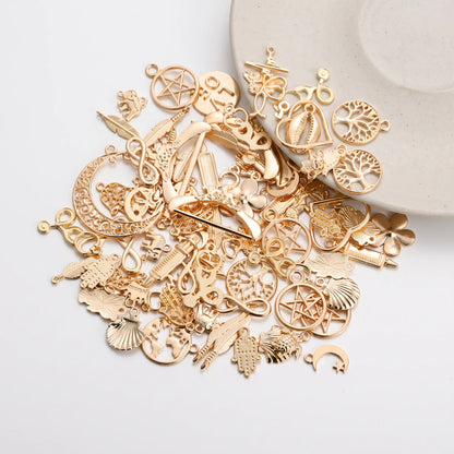 Mixed gold tone charms with hearts trees feathers flowers and assorted decorative designs