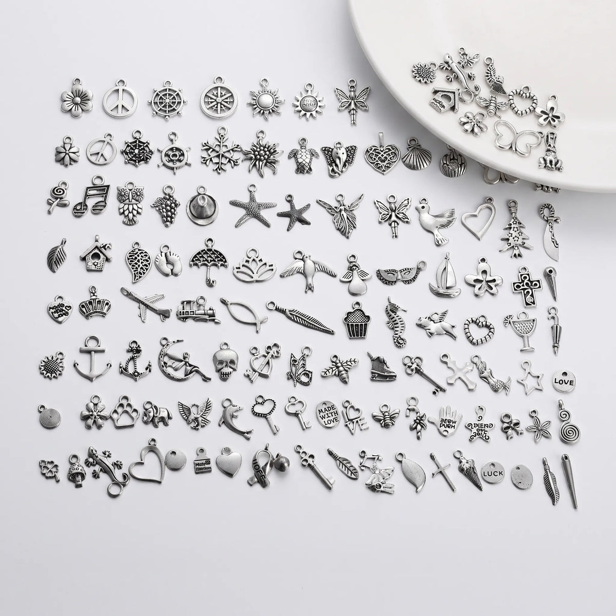 Assorted silver tone charms in mixed designs for bracelets necklaces and crafts
