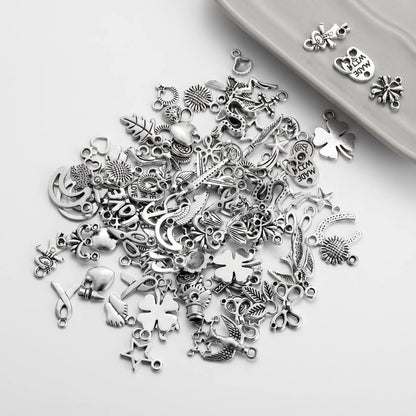 Mixed silver tone jewelry charms with assorted flowers, stars, leaves and decorative designs
