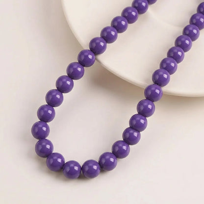 Opal purple coated glass round beads arranged on a 16 inch strand
