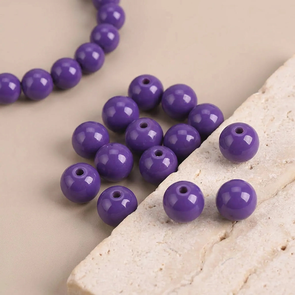 Close-up of opal purple coated glass round beads showing smooth surface and bead holes
