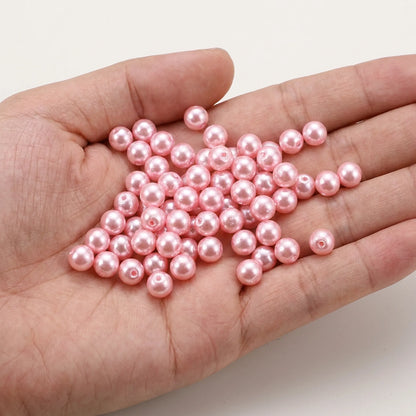 Pink Czech Glass Pearl Beads shown in hand for size comparison, pearl coated round glass beads for jewelry making