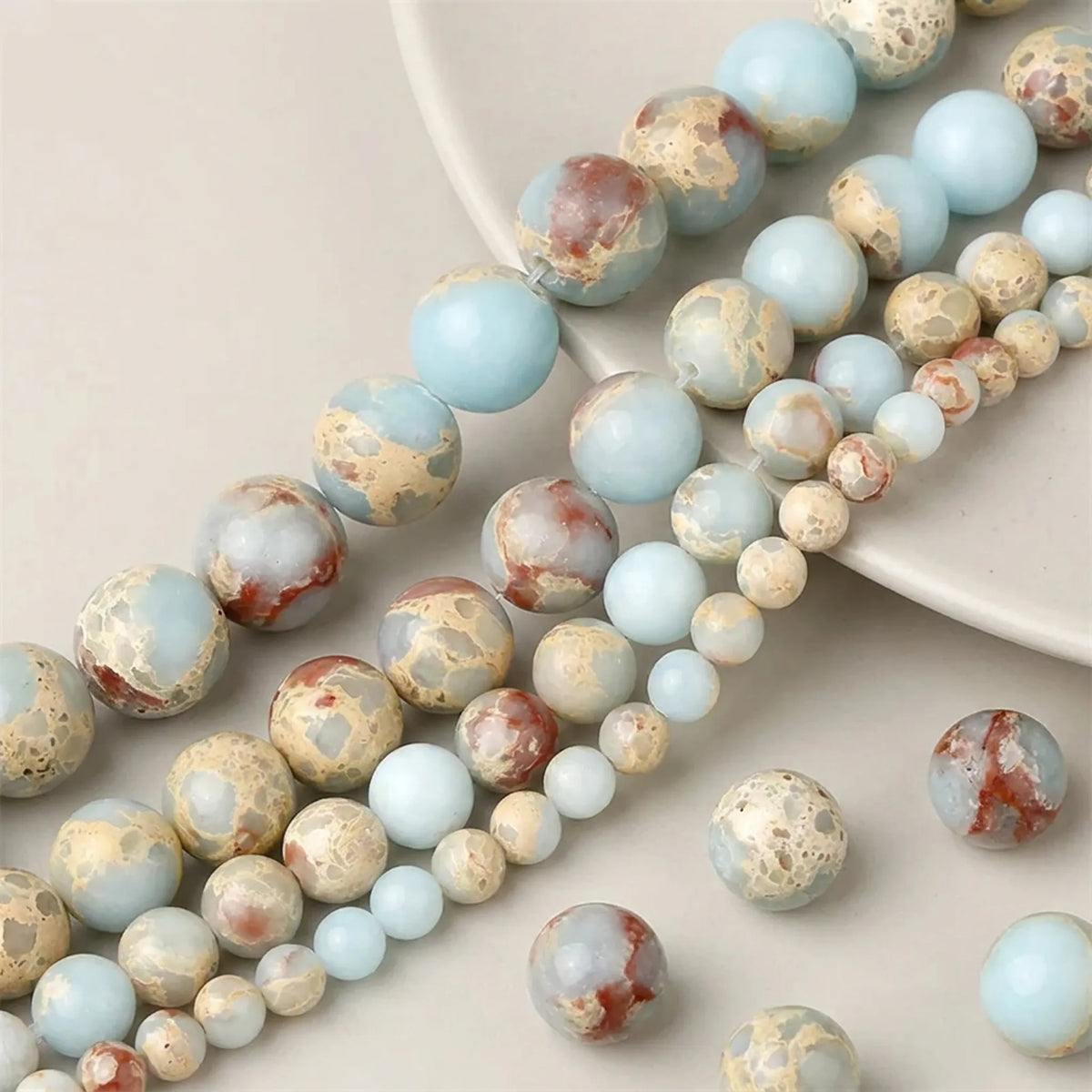 Close-up of smooth natural Shoushan Jasper round beads in 4–12mm sizes