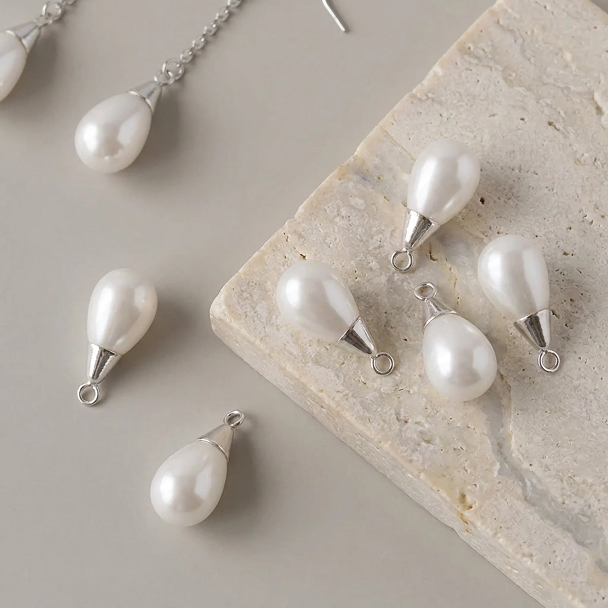Sterling silver pearl cup bails attached to white drop pearls for pendant and earring making