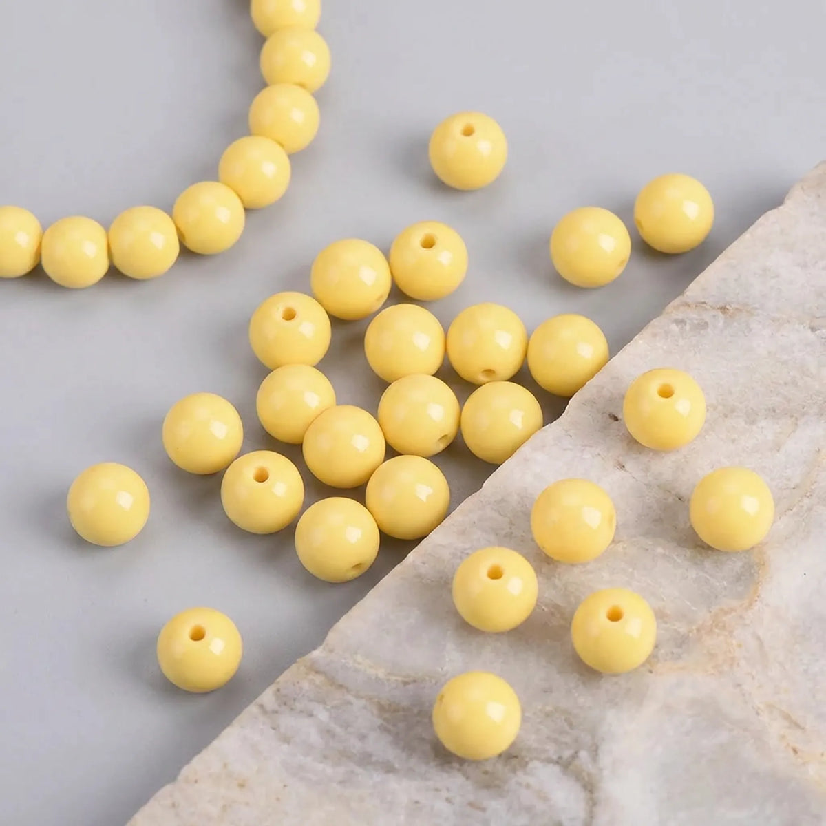 Yellow coated opaque glass round beads used in a handmade bracelet