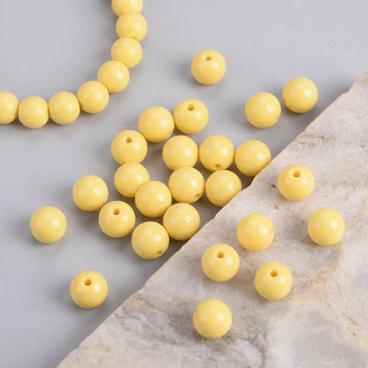 Yellow coated opaque glass round beads used in a handmade bracelet