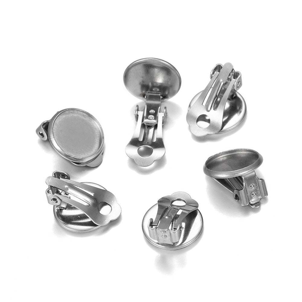 A collection of stainless steel round flat ear clip bases of various sizes, displayed on a white background.
